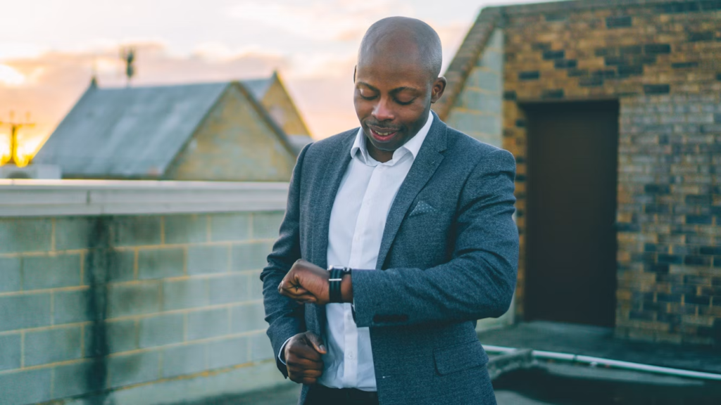 homme en costume gris tenant un smartphone noir
