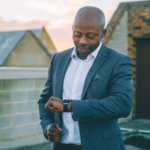 homme en costume gris tenant un smartphone noir